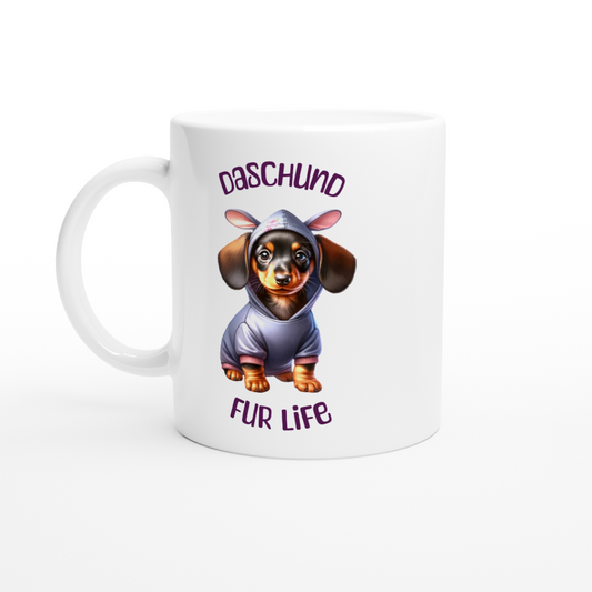White ceramic mug with cute Daschund puppy wearing a romper with hood